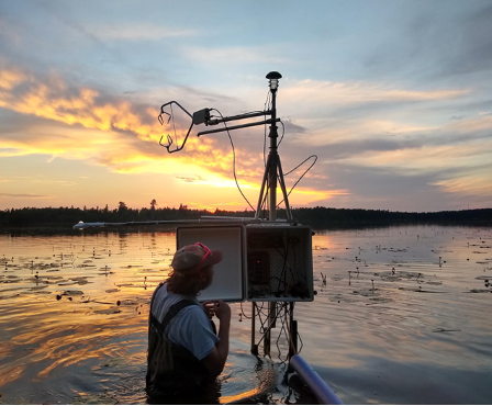 Researcher adjusting equipment on Lake Itasca
