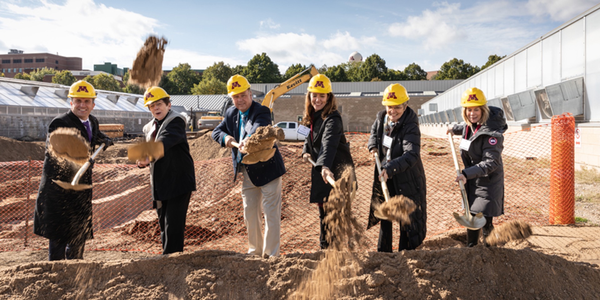 Photograph of six people with shovels and yellow hard hats digging in a pile of dirt on the site that would become the CBS Conservatory & Botanical Collection