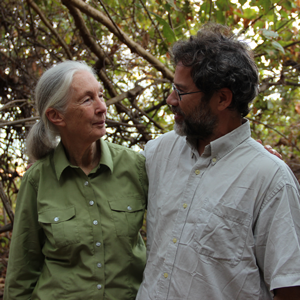 Michael Wilson wears a gray shirt and stands by Jane Goodall who wear a green shirt