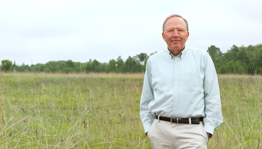 Dave Tilman standing in a field at Cedar Creek