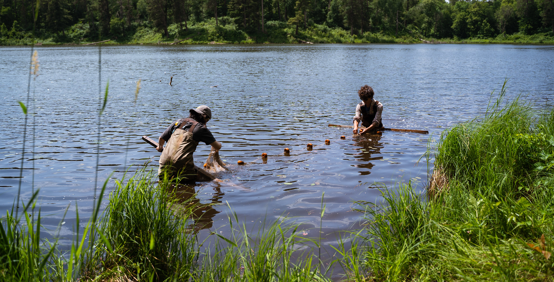 Two students standing in Lake Itasca