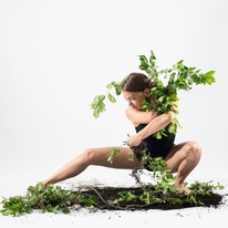 dancer Brenna Mosser posing with vegetation and soil