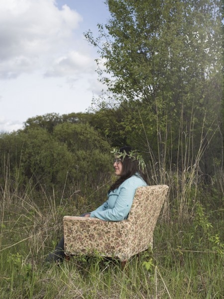 Cristy Portales-Reyes seated in a chair in field at Cedar Creek