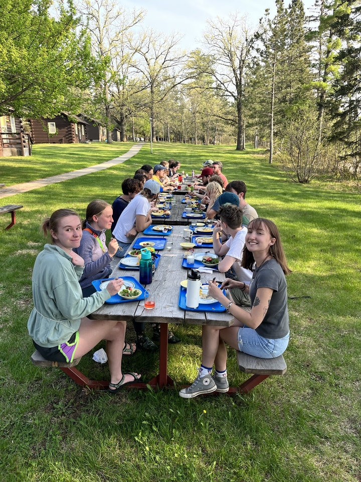 Students eating outside at picnic tables at Itasca Station