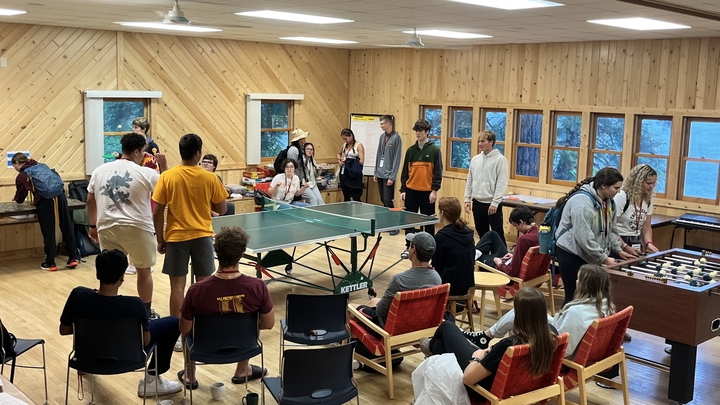 Students playing ping pong, foosball, and putting together a puzzle in the IBSL Assembly hall