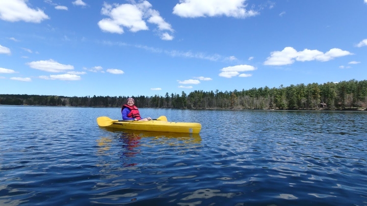 Student in a yellow kayak on Lake Itasca