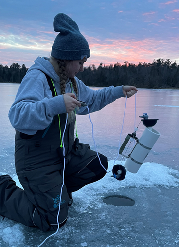 Leah Glimsdal holding an acoustics device on a frozen lake
